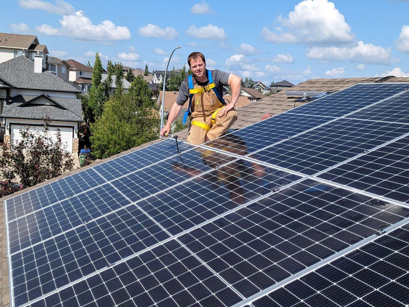 A professional solar installer inspecting a roof in Okotoks, AB.